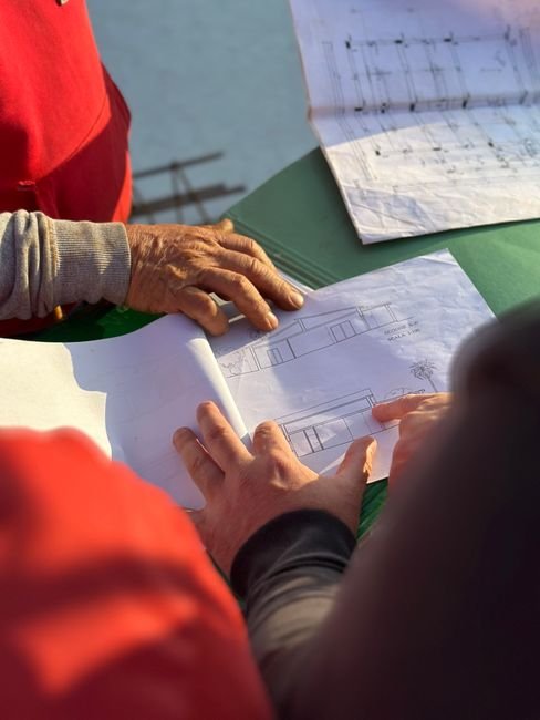 architects reviewing blueprints on construction site