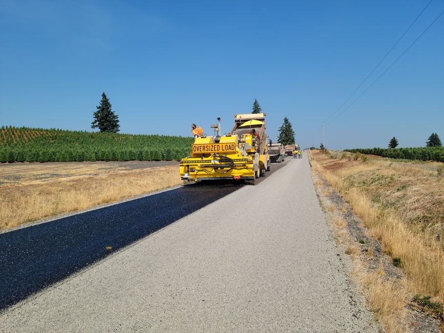 heavy machinery paving a road with asphalt during daytime