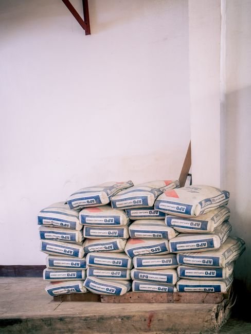 stacks of steel rebar and cement bags in construction warehouse