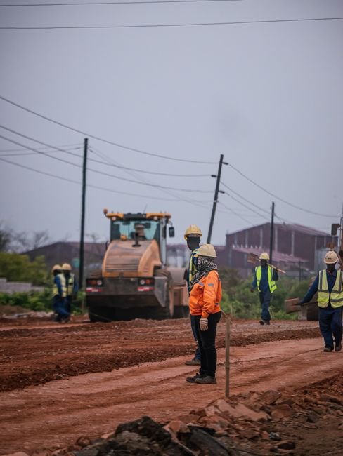civil engineers inspecting urban asphalt road construction site in hot weather