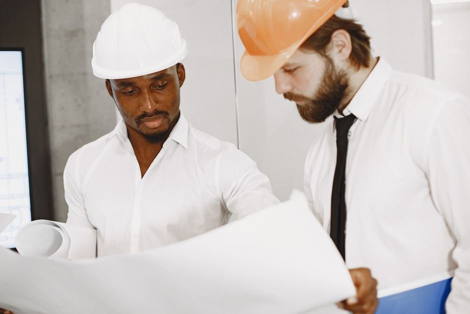 construction engineers reviewing 3d building information modeling blueprints on site