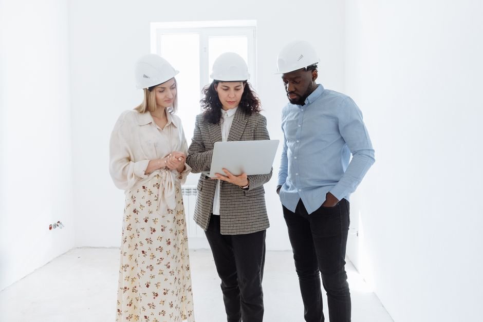 construction engineers reviewing architectural plans on a laptop at a desert site