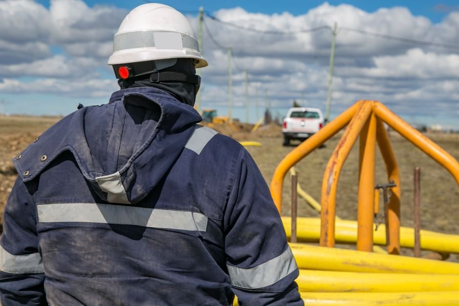construction workers inspecting water pipeline infrastructure in arid desert landscape
