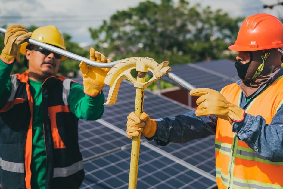construction workers installing solar panels in arid climate with machinery