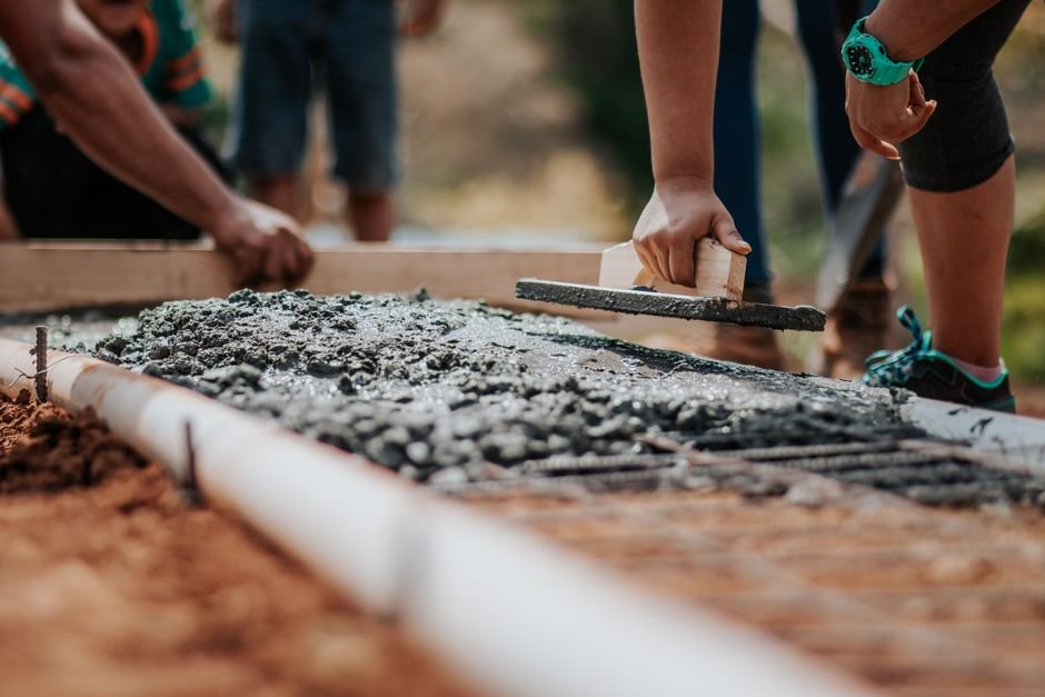 construction workers pouring ready mix concrete on a structural slab