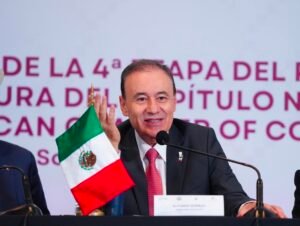 El gobernador de Sonora, Alfonso Durazo, sostiene una bandera de México durante el encuentro binacional con Arizona
