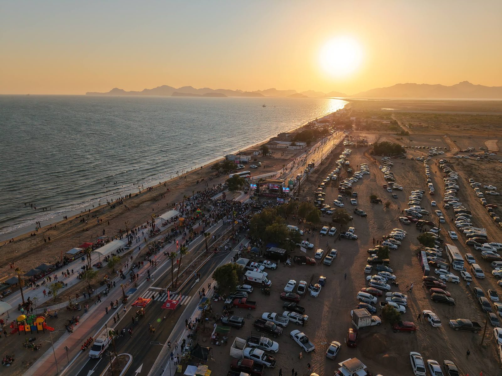 Vista aérea del Malecón El Cochórit al atardecer, con visitantes recorriendo el paseo costero en Empalme, Sonora