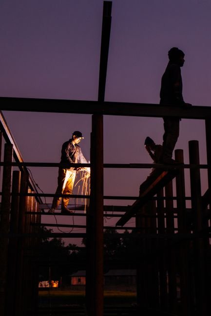 engineers inspecting steel bridge welding sunset