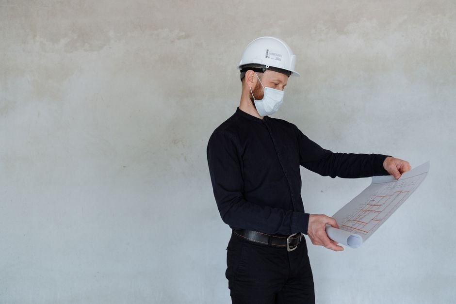 Engineers reviewing architectural blueprints on a modern construction site with solar installation