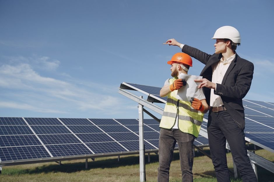 engineers reviewing architectural plans on a green construction site with solar energy installations
