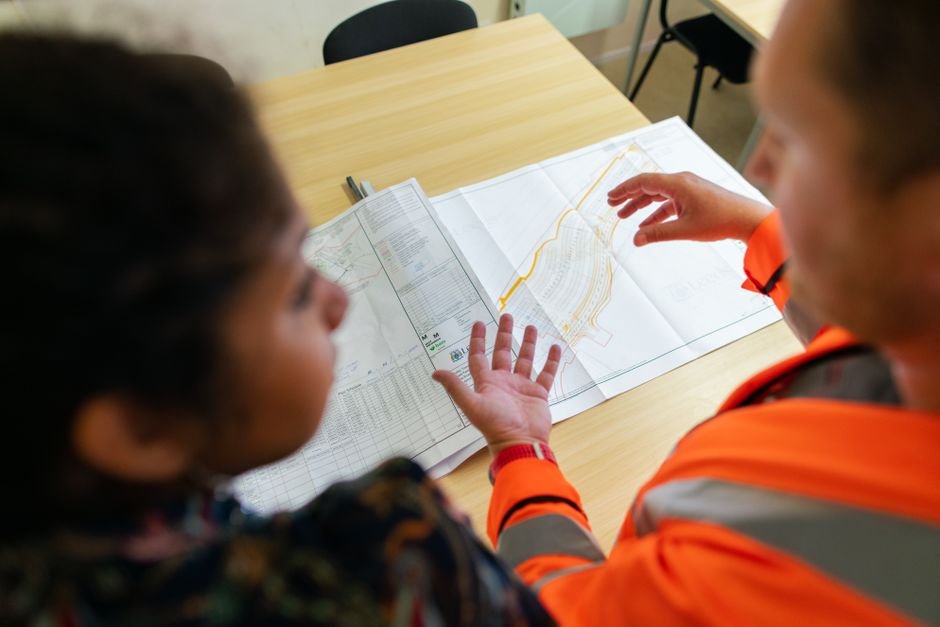 engineers reviewing blueprint at border construction site modern highway