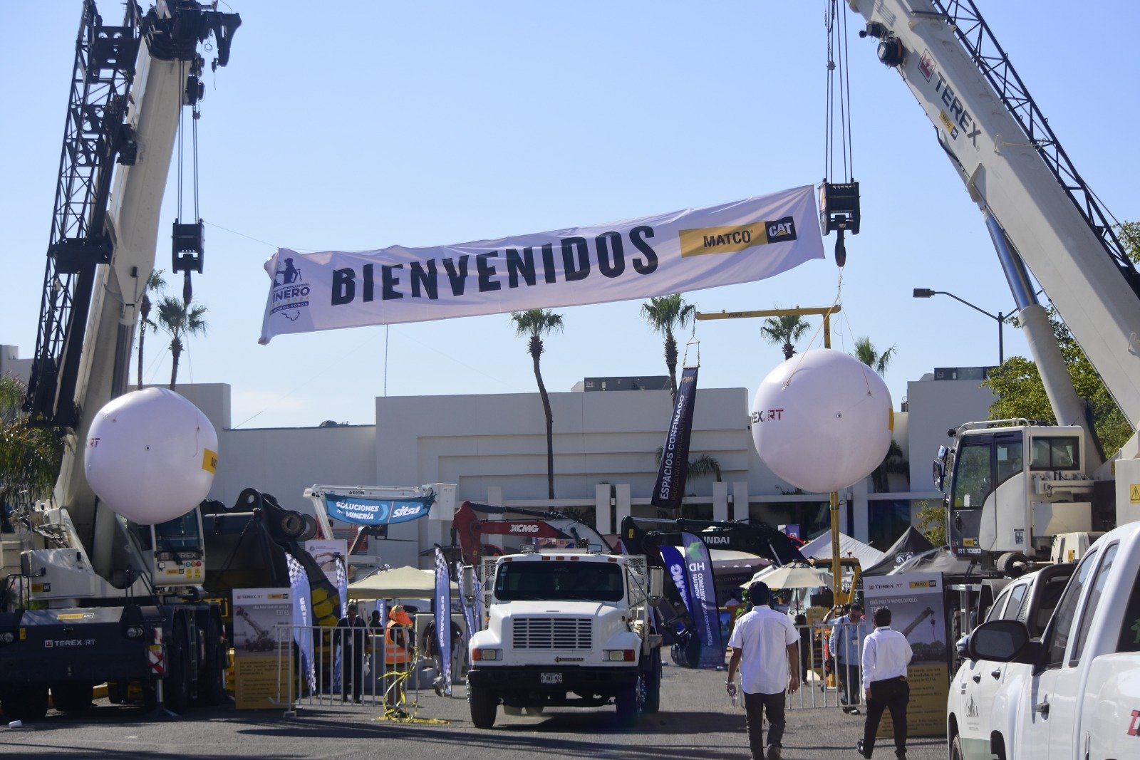 Acceso a la Expo Minera con maquinaria pesada y el banner de bienvenida
