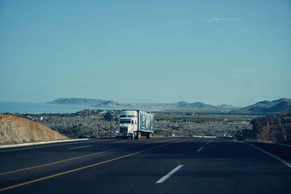 heavy trucks driving on modern highway in desert landscape Mexico