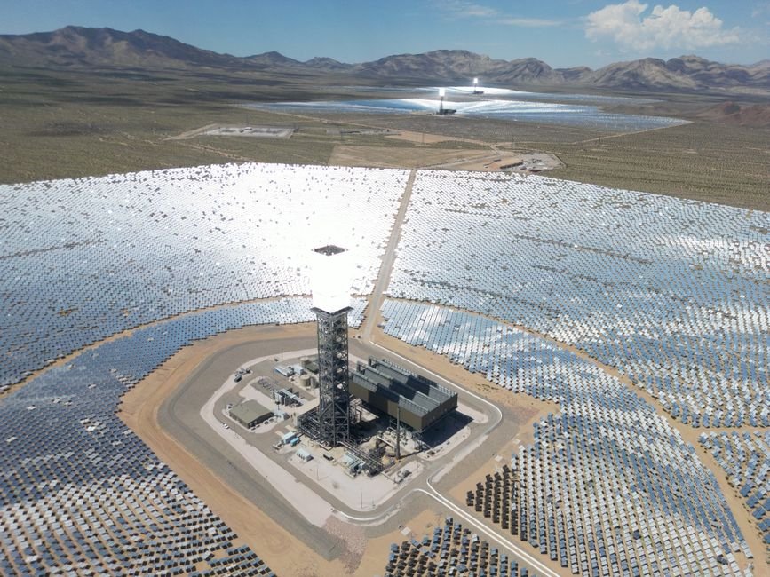 large scale solar farm panels in the desert with engineers working