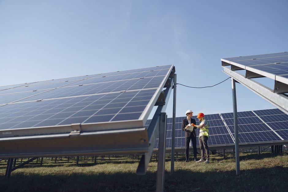 large solar farm in desert landscape with engineers inspecting panels