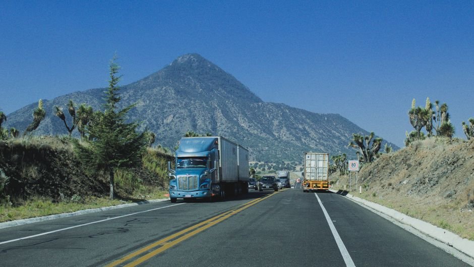 Modern highway infrastructure crossing the US Mexico border with heavy truck traffic
