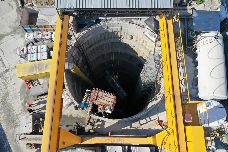 modern tunnel boring machine and mining engineers inspecting construction