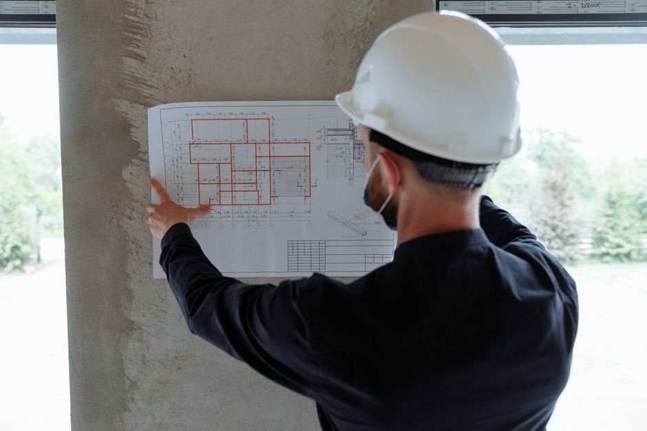 structural engineer inspecting modern building foundation with blueprints