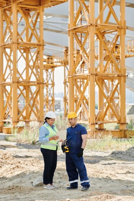 construction engineers reviewing a 3D BIM model on a digital tablet at a job site