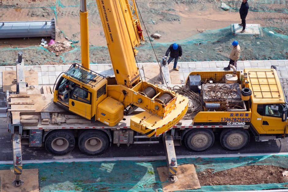 construction workers on a modern building site with heavy machinery and blueprints
