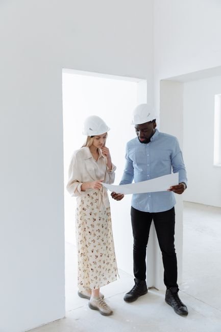 engineers reviewing architectural plans on a tablet at a modern construction site