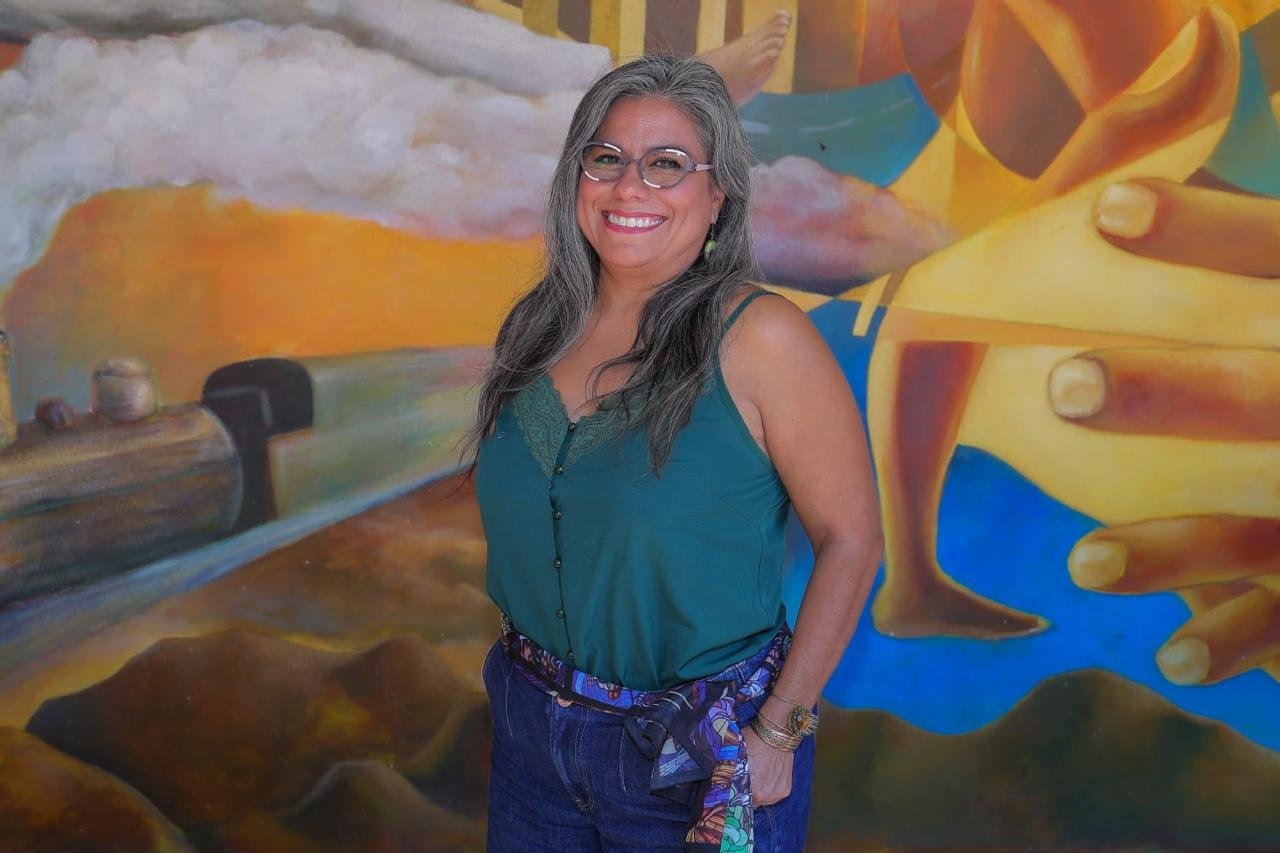 Académica de la Universidad de Sonora frente a un mural del campus Hermosillo