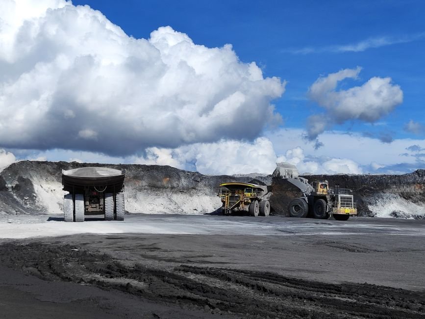 heavy machinery working at a large open pit gold mine in the desert