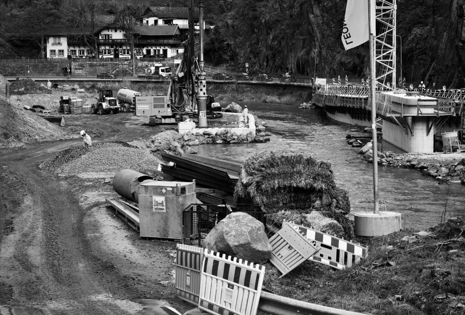 modern border bridge construction with heavy machinery and engineers