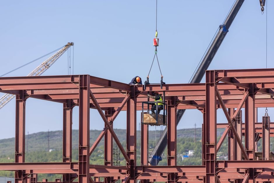 steel structure construction site with workers and beams
