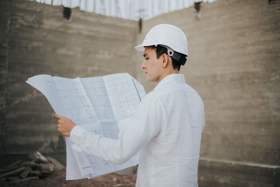 Construction workers reviewing architectural plans on a sustainable building site in Mexico