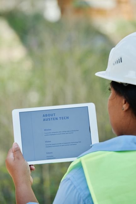 Engineers reviewing digital blueprints on tablet at construction site
