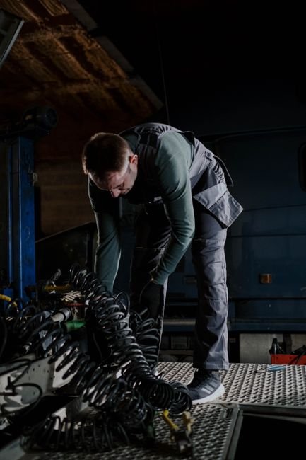 Mechanic servicing a heavy excavator engine in a workshop