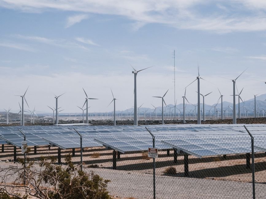 Modern solar panels integrated into the roof of a large industrial building in the desert