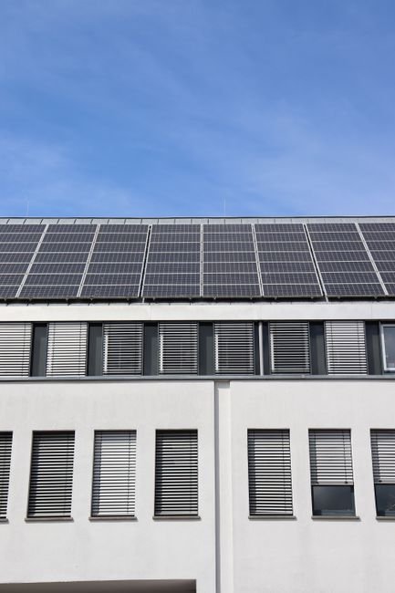Modern sustainable building facade with solar panels in a desert landscape