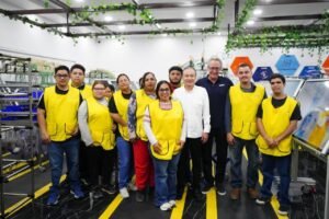 Trabajadores con chalecos amarillos y funcionarios en el área de producción de una planta de LEONI.