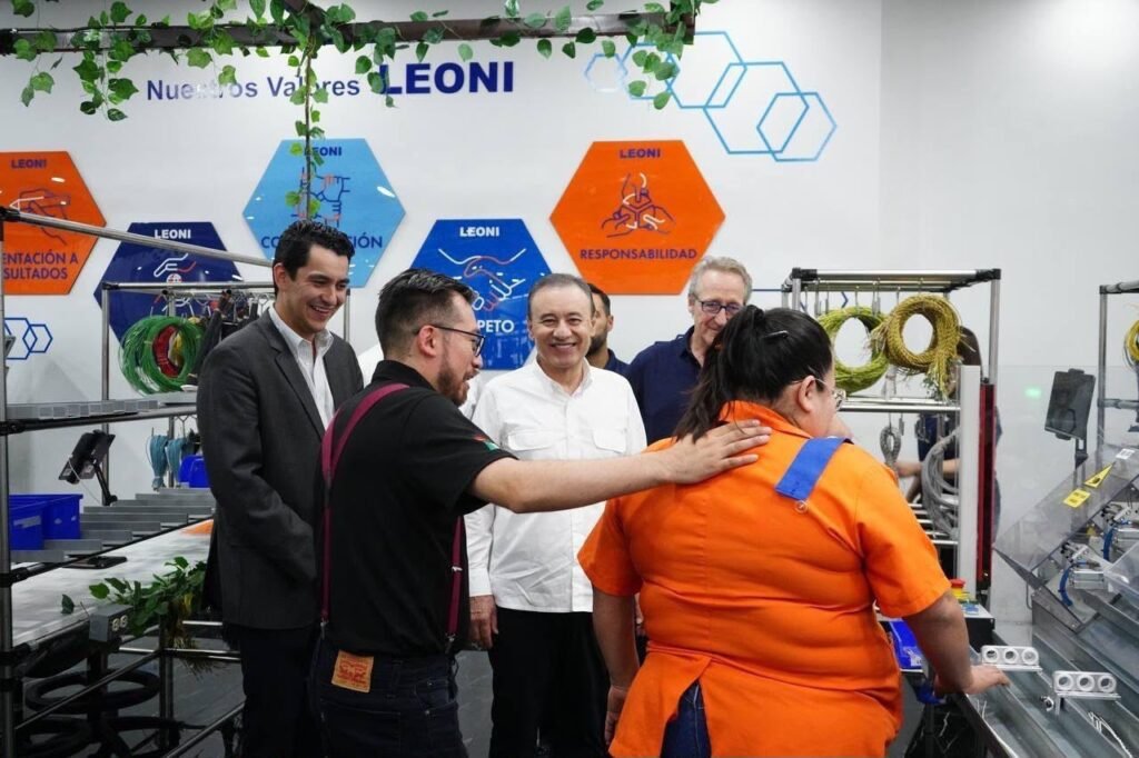 Recorrido por la línea de producción; al fondo, el muro con los valores de LEONI.